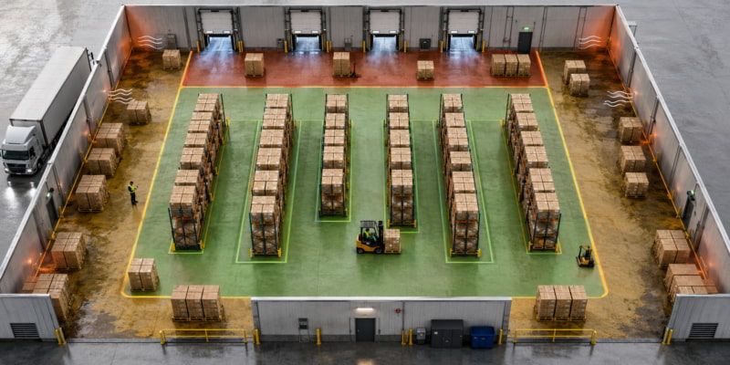 Top-down warehouse map showing corrugated box storage zones with green safe aisles and red humidity-risk dock areas.