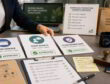 Operations desk with approved signage, staff scripts, claim review cards, and paper bags for a store rollout.