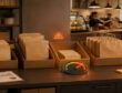 Inventory desk with paper bag bins, a low-stock warning gauge, and a cafe counter in the background.