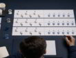 Overhead view of a planner comparing alternating forecast errors and one-sided bias using paper cup tokens on a desk.